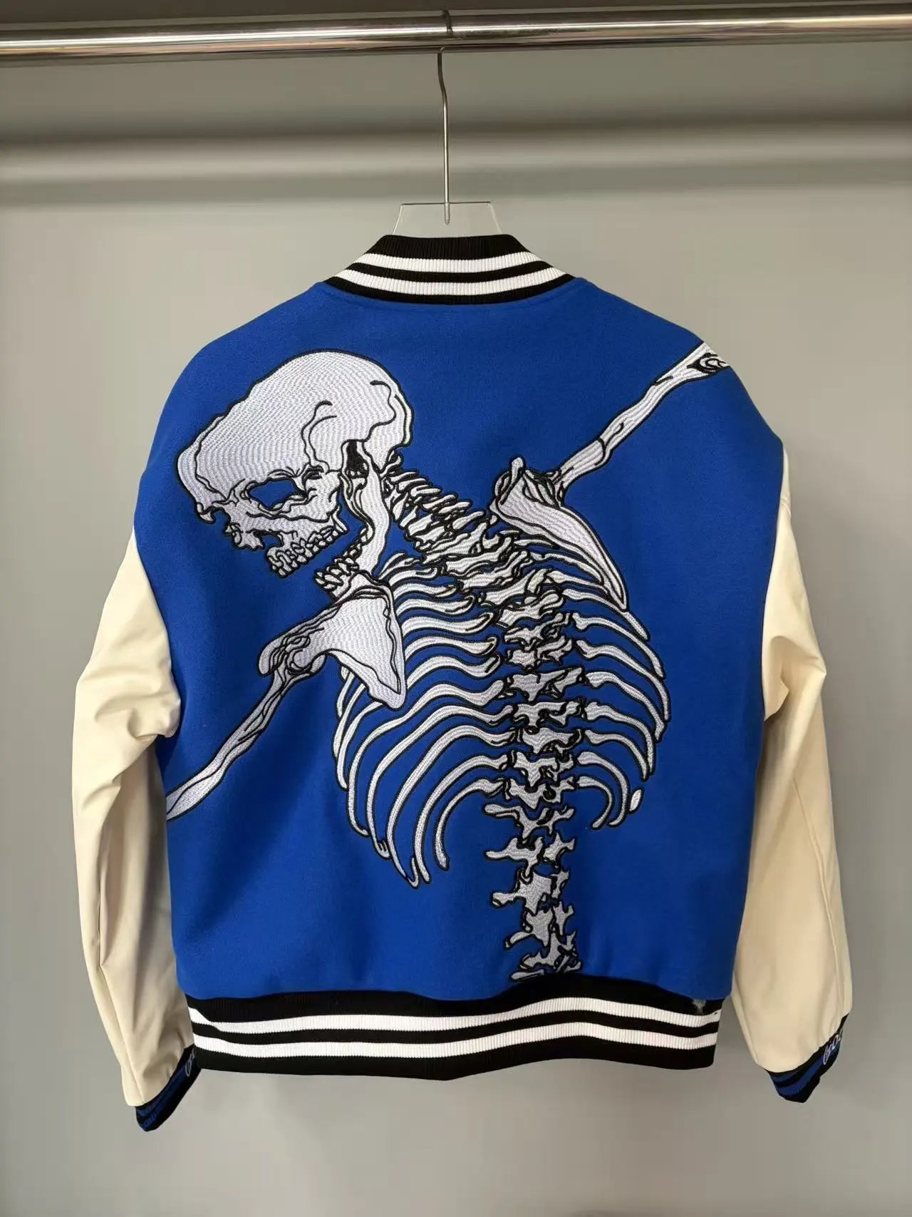 Blue Varsity Jacket with Embroidered Skeleton Design Cream Sleeves