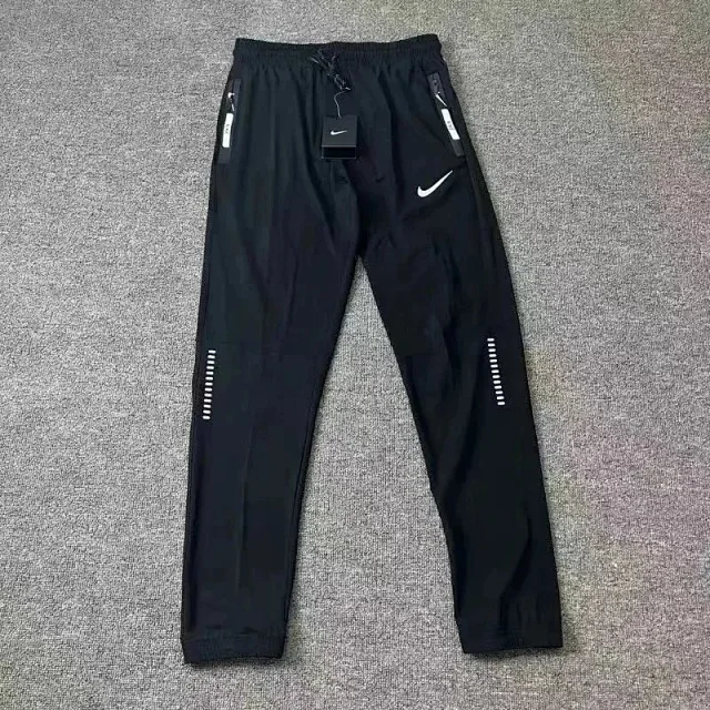 Nike Trousers Tapered running with ribbed lower-leg panels and zip pockets product detail image 1
