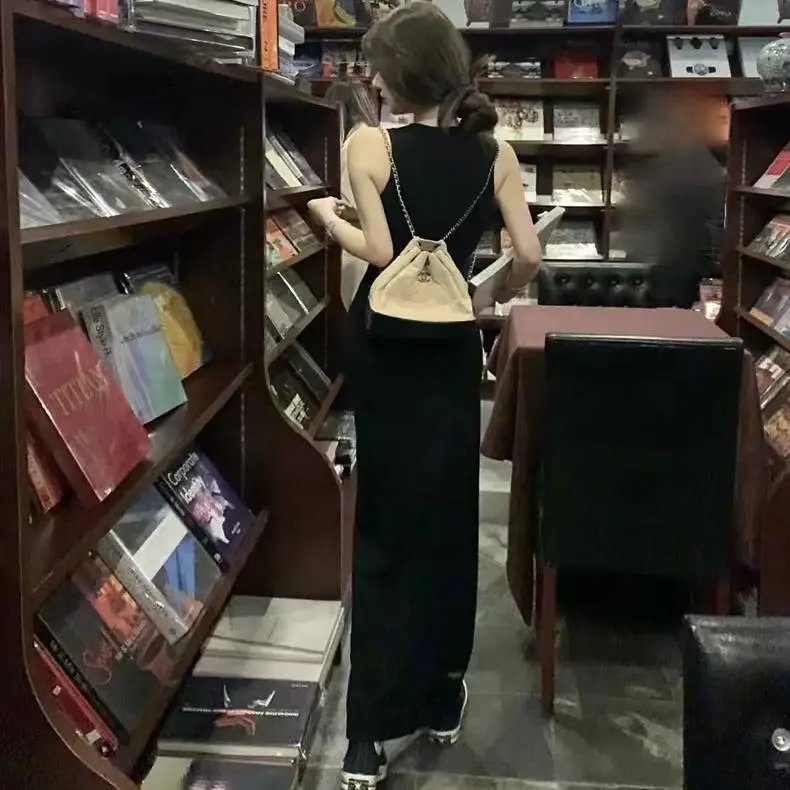 Sleeveless Black Maxi Dress with a Beige Bucket Bag