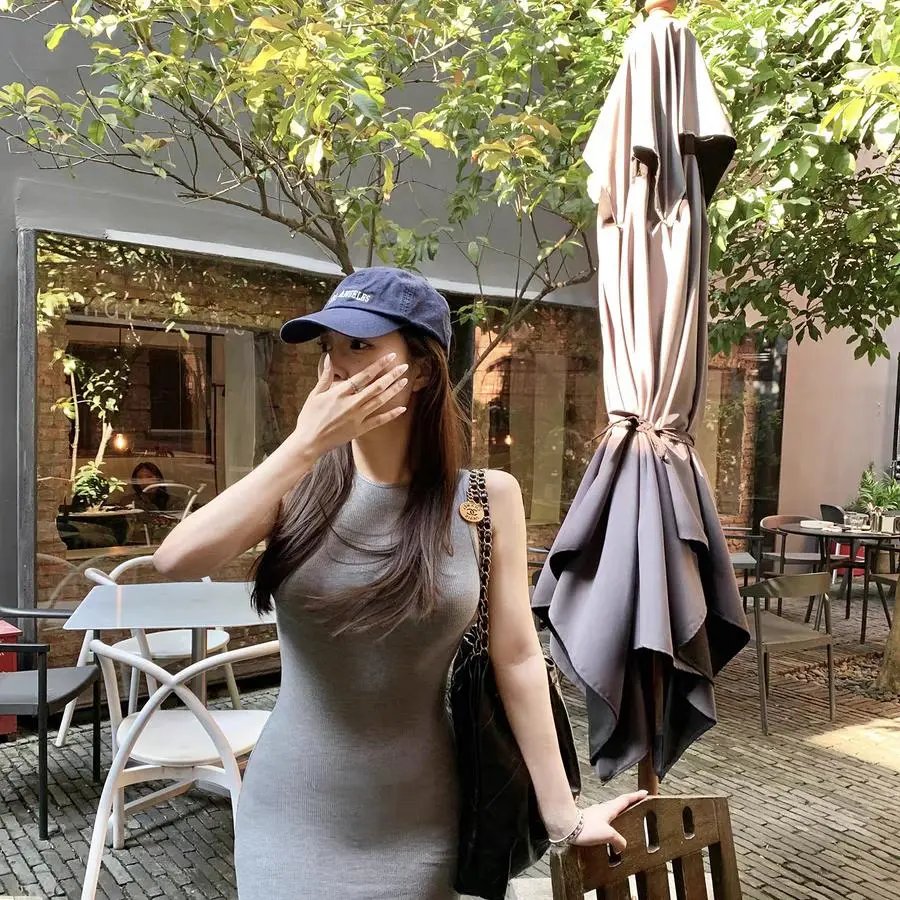 Sleeveless Black Maxi Dress with a Beige Bucket Bag
