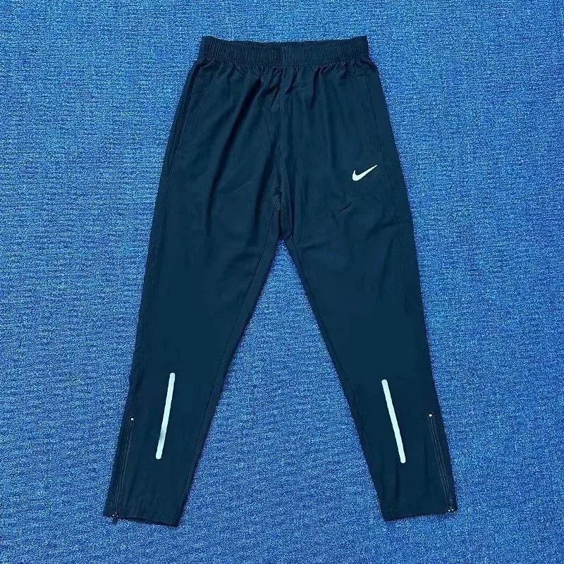 Nike Trousers Tapered running with zip pockets and reflective details — 32