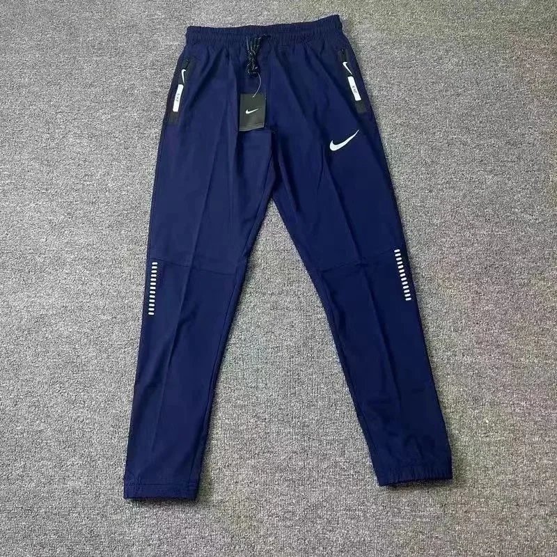 Nike Trousers Tapered running with zip pockets and reflective details — 28