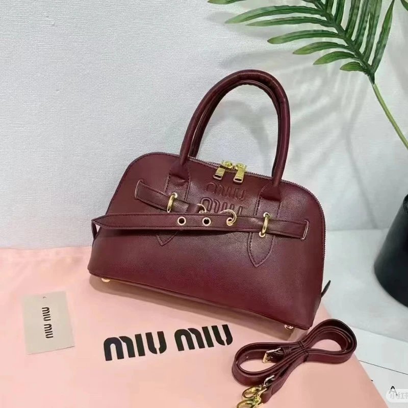 Miu Handbags Dome handbag with belt-style gold-tone hardware and detachable shoulder strap — Wine red