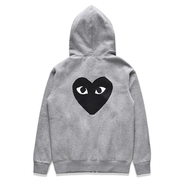There is a big black heart behind the velvet gray cardigan