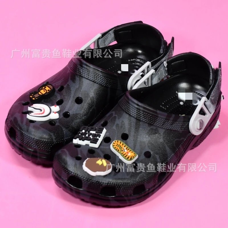 black camouflage-patterned clog sandals with multiple removable charms, strap closure, ventilation holes