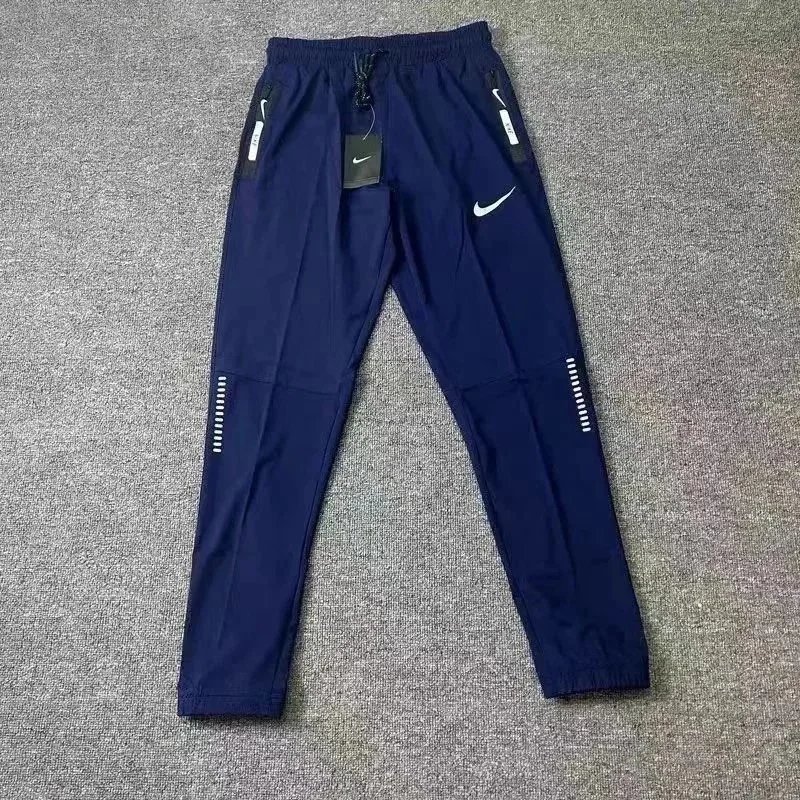 Nike Trousers Tapered running with zip pockets and reflective details — 28