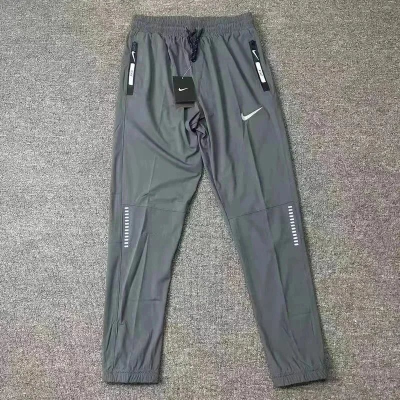 Nike Trousers Tapered running with zip pockets and reflective details — 24
