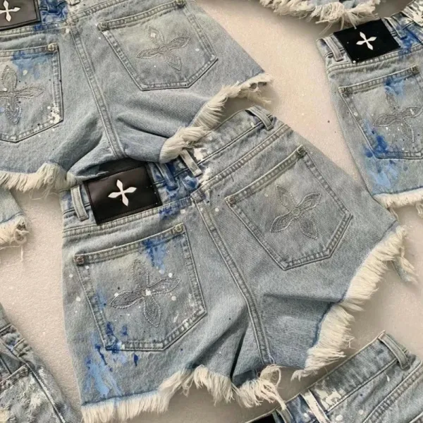Design Embroidered Fleur-de-Lis Denim Shorts with Frayed Hem and Paint Splatter Detail - 1