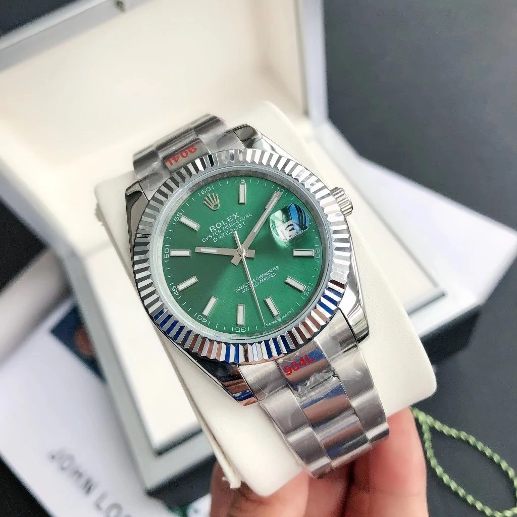 Rolex Watches Datejust fluted-bezel bracelet watch — Silver case with a green dial, three-link steel bracelet, and mineral‐strengthened hardlex glass.
