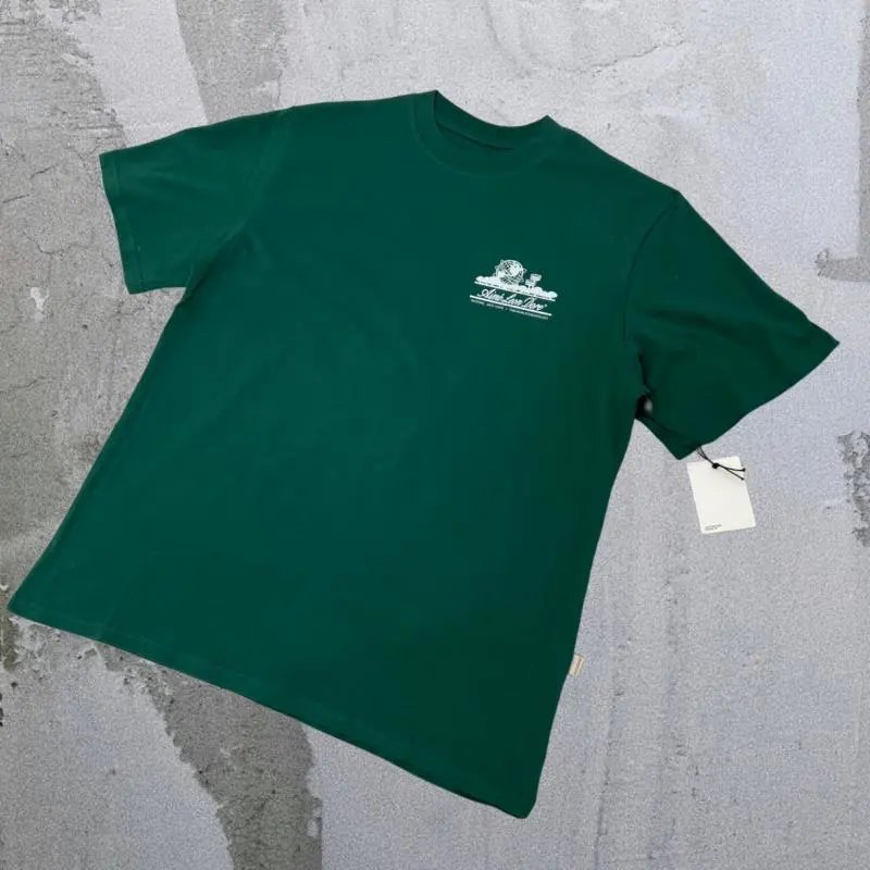 Aimé Leon Dore T-Shirts Short-sleeve logo graphic T-shirt — Landmark A01 behind the green
