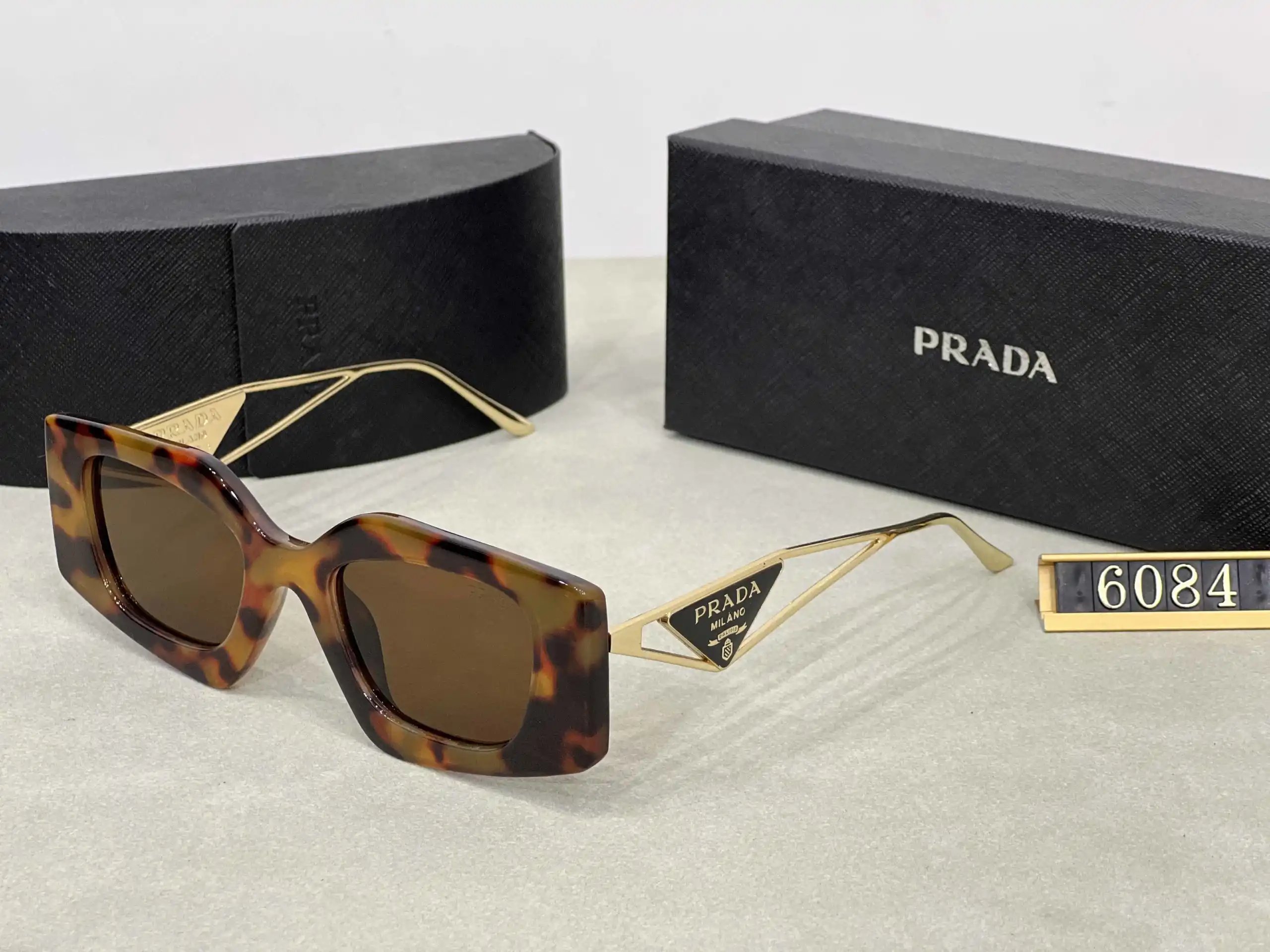 Prada Eyewear Assorted geometric-frame sunglasses with triangle logo plaques — 18