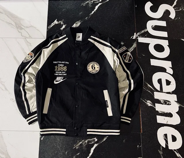 Nike Jackets Varsity-style snap-front jacket with contrast striped sleeves and patches product detail image 1