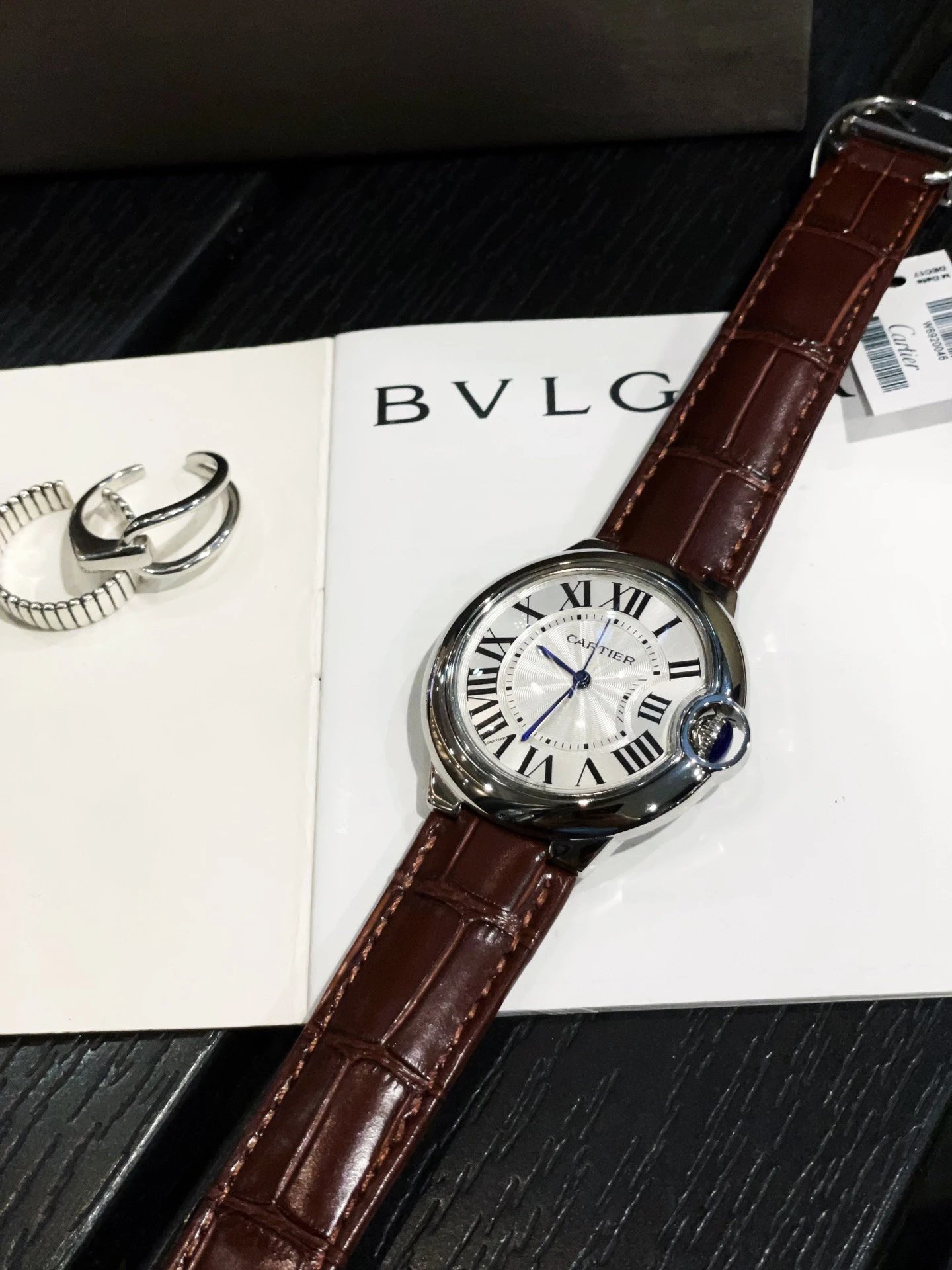 Zegarek Cartier z białą tarczą z cyframi rzymskimi i brązowym skórzanym paskiem