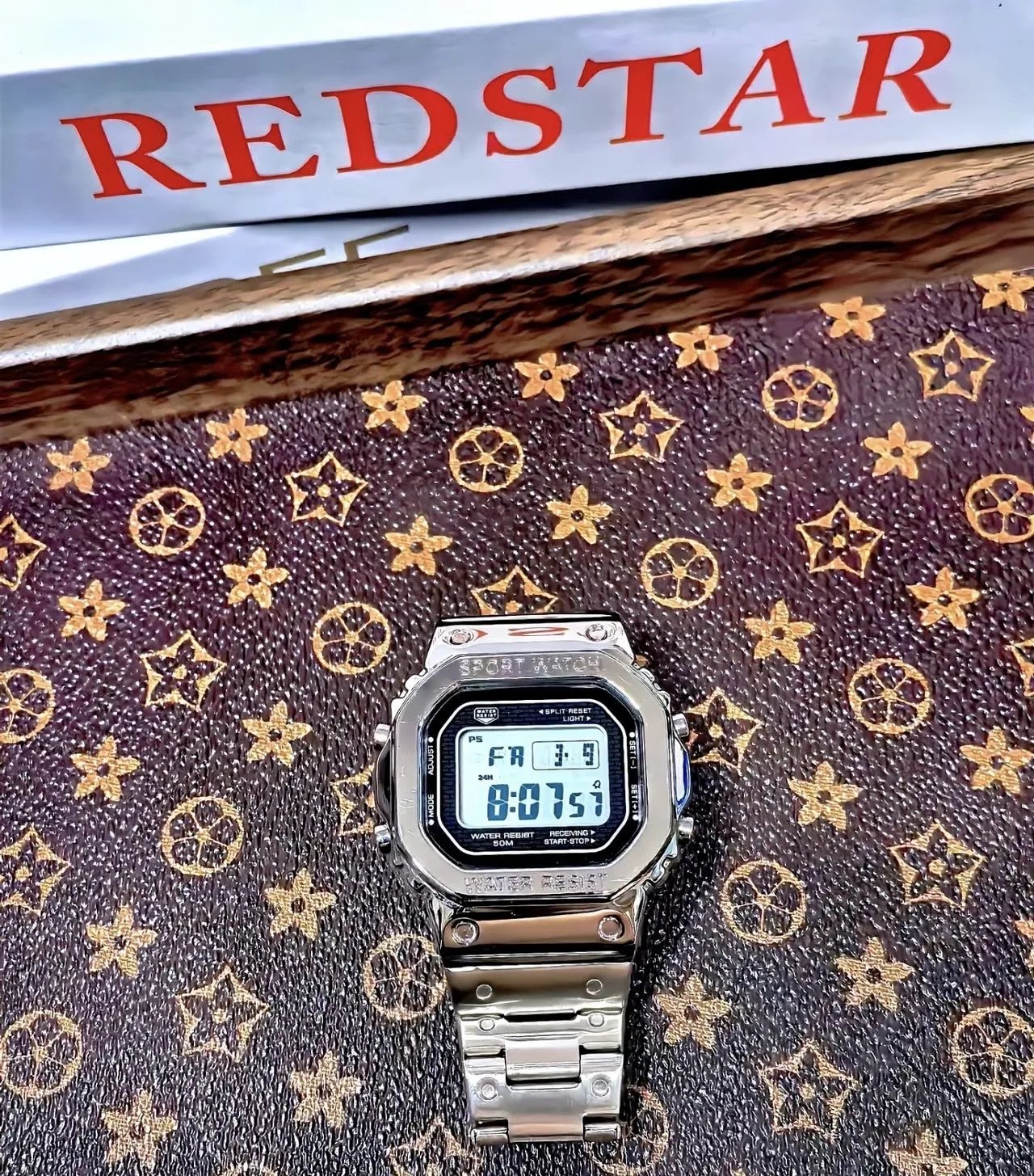 Digitale Sportuhr mit silberfarbenem Gehäuse und Gliederarmband