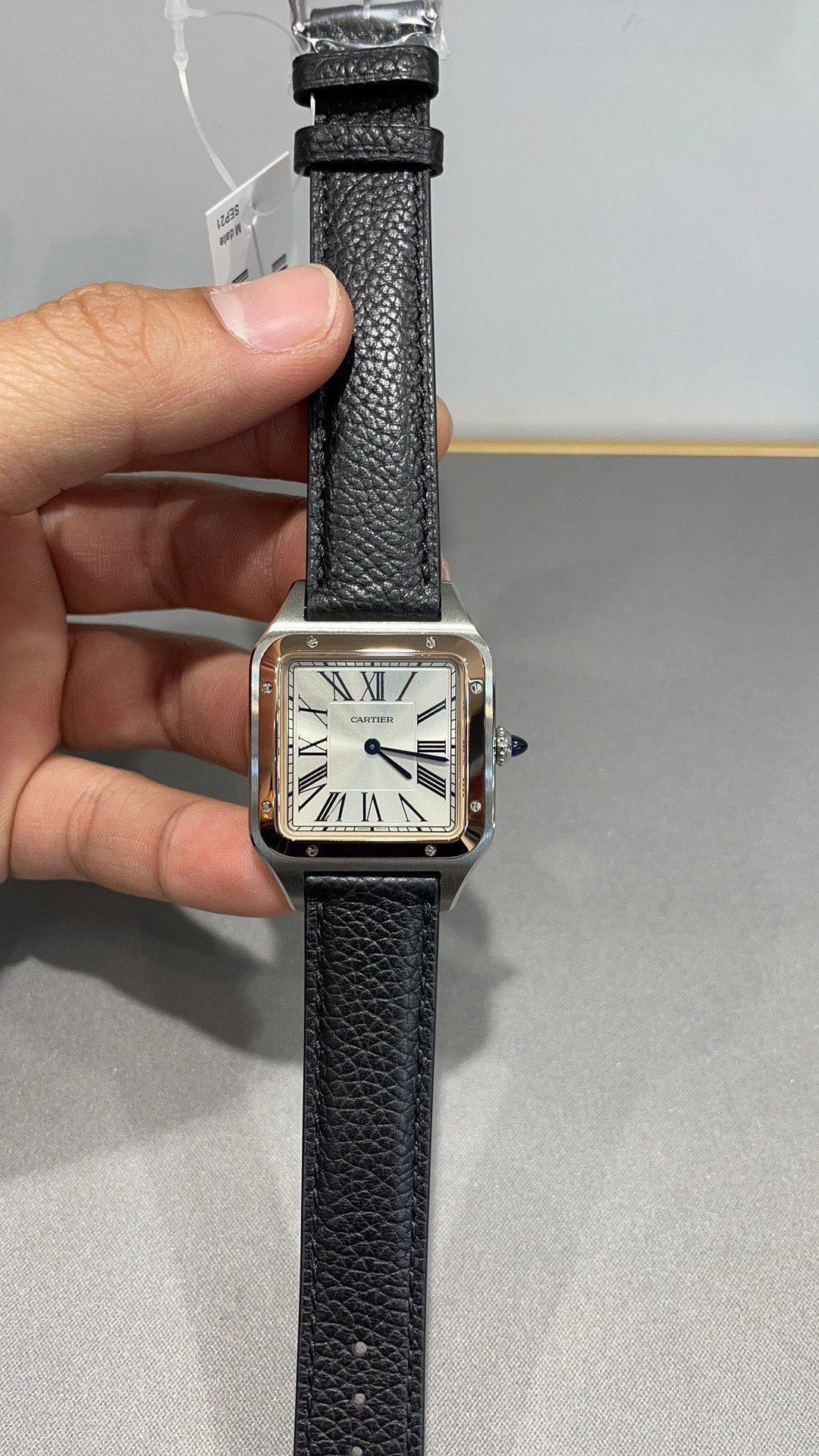 Tweekleurig vierkant Cartier horloge met zwarte lederen band