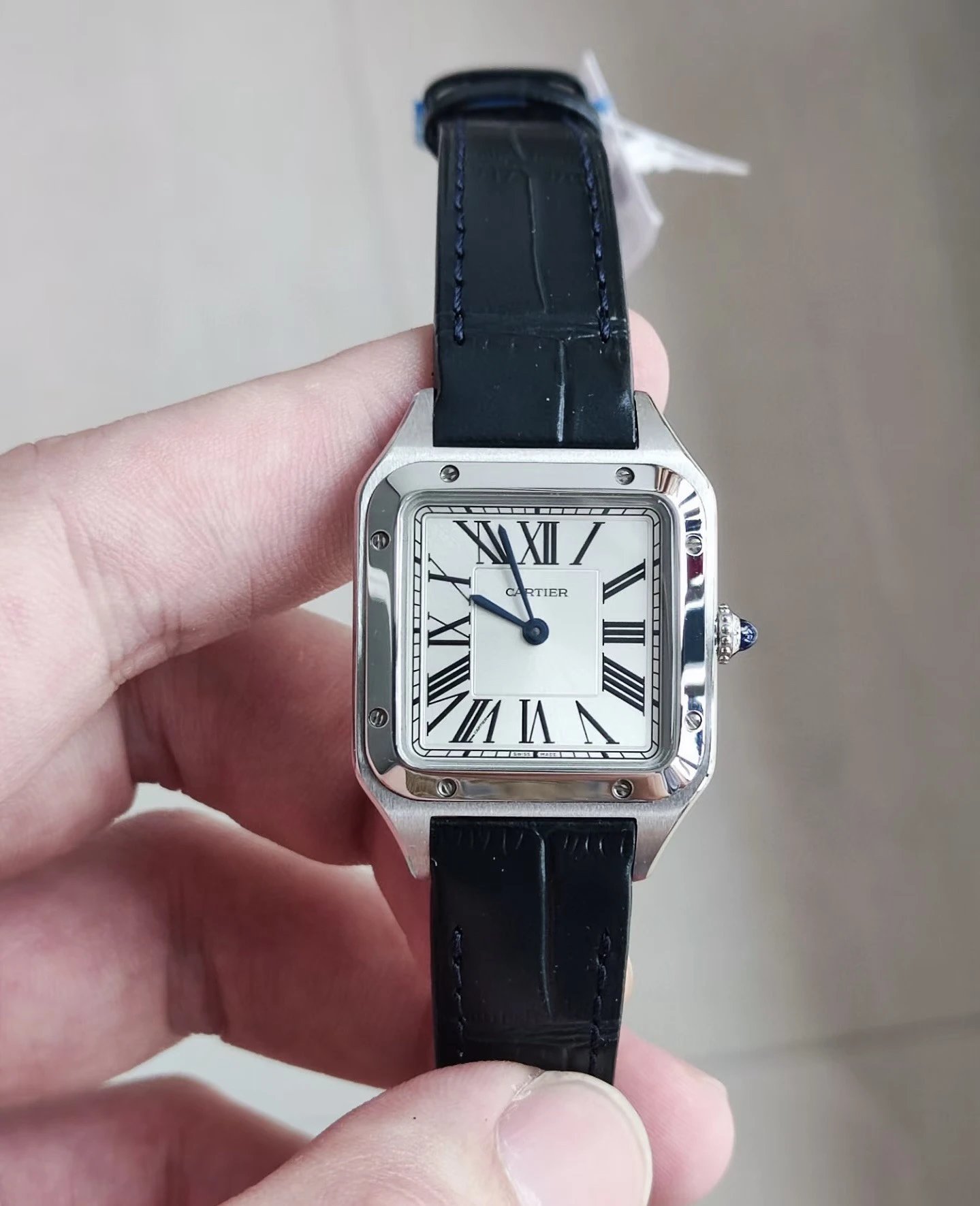 Vierkant Cartier horloge met zwarte lederen band en Romeinse cijfers op de wijzerplaat