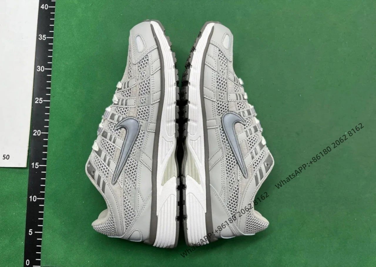 Nike Light gray mesh upper with synthetic overlays, silver swoosh logo, white midsole, black outsole
