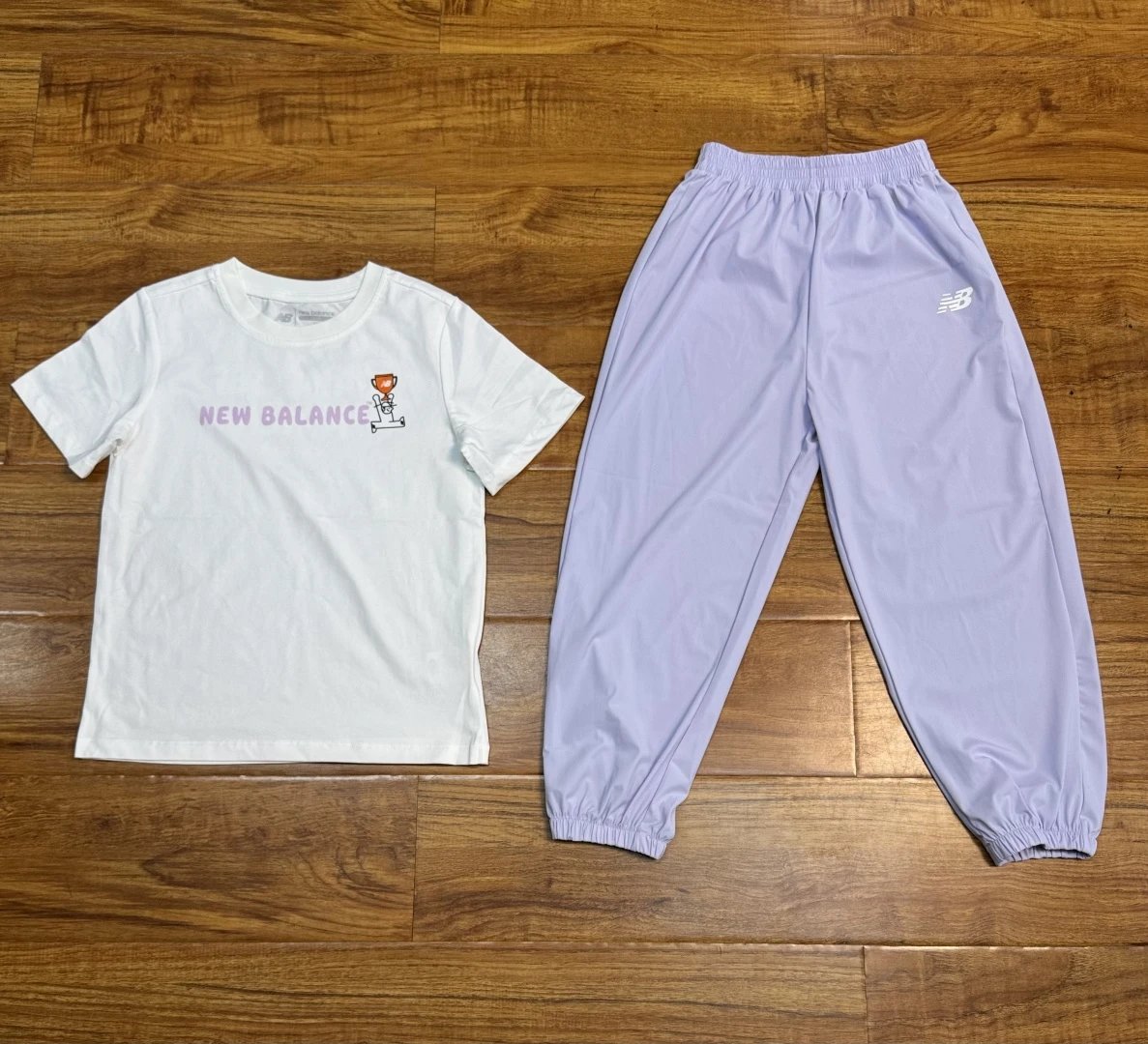 New Balance Kids NB儿童网球主题系列 米白凉感棉短袖，后背印花标语 GAME, SET, MATCH（网球术语：赛点、一盘结束），属于网球复古