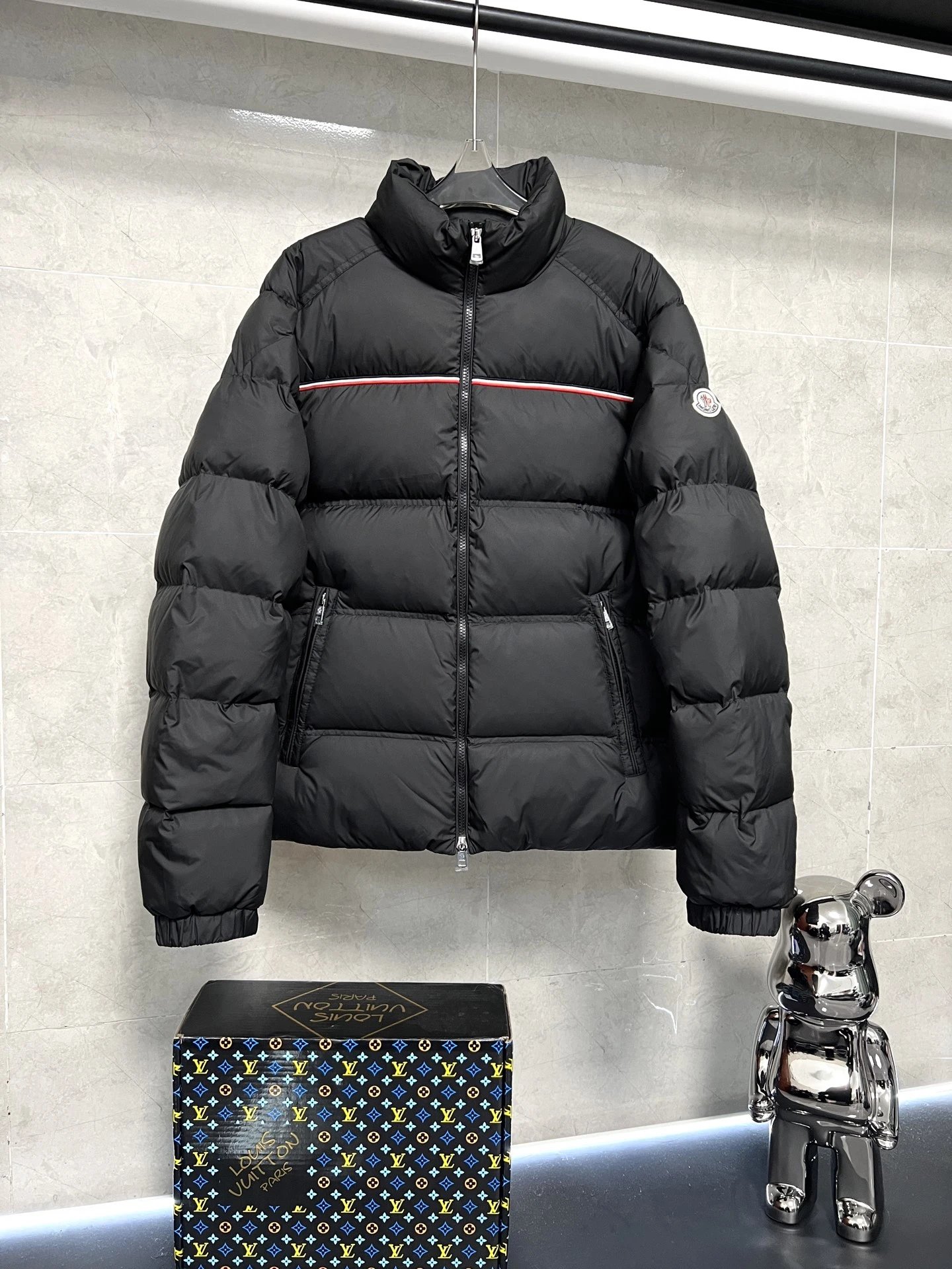 Moncler盟可睐Bouvaque 短款拉链立领长袖夹克，立领设计简约大气，胸前红黑条纹装饰增添时尚感，填充饱满的羽绒保障绝佳保暖性