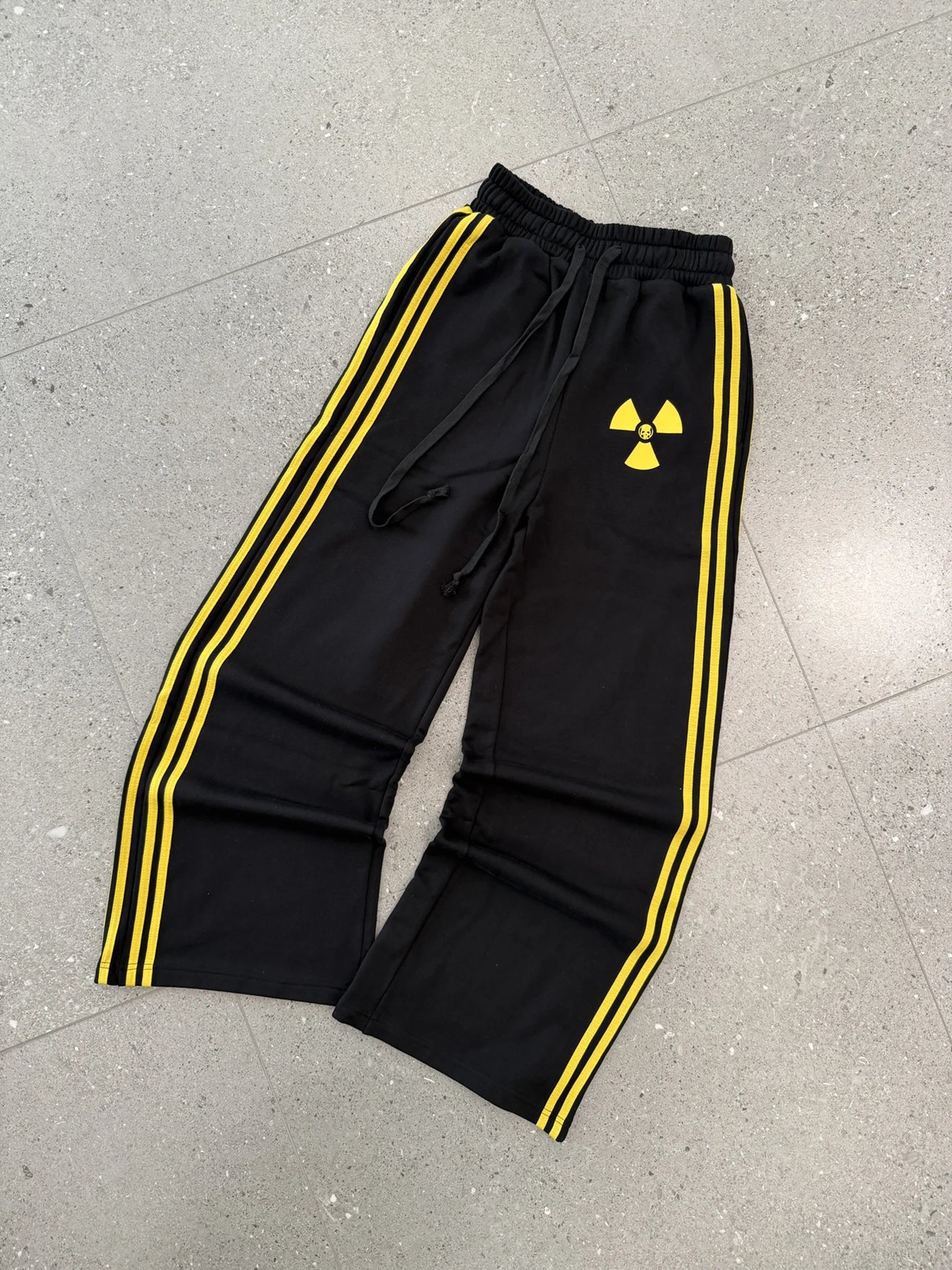 Black Track Pants with Yellow Stripes and Radiation Symbol Graphic