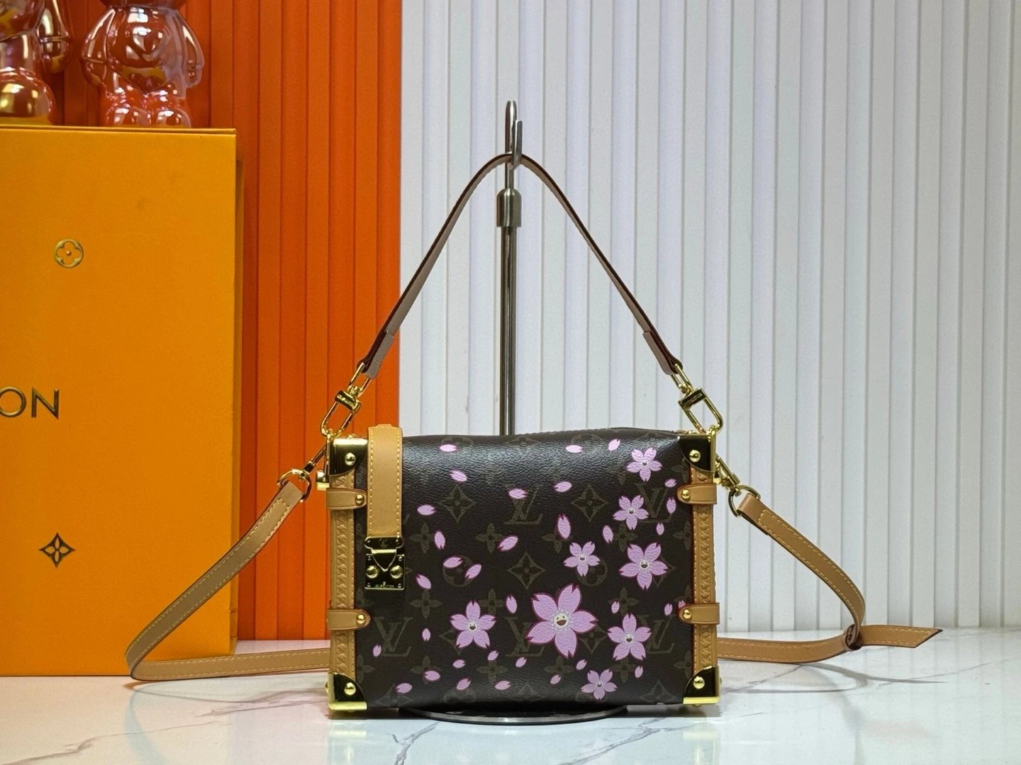 Sakura Side Trunk Medium Handbag! Drawing color inspiration from the brand's vintage hard cases, rendering elegant French tones on the iconic canvas, with calf leather trim and shiny metal hardware, easily blending into the current ready-to-wear collection.